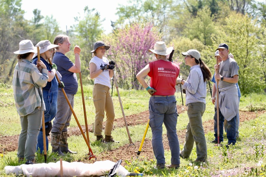 Liza (in white t-shirt in the center) with Staff and Growers meeting and talking out in the fields.